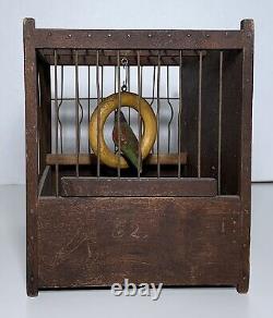 Art populaire ancien : Oiseau sculpté et peint sur une balançoire dans une cage