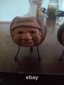Deux porte-bougies ou porte-allumettes en noix de coquilla sculptés à la main, art populaire du XIXe siècle.