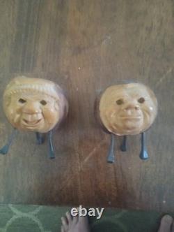 Deux porte-bougies ou porte-allumettes en noix de coquilla sculptés à la main, art populaire du XIXe siècle.