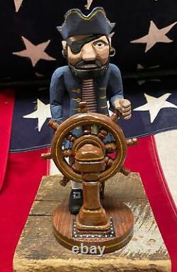 Figure du capitaine pirate en bois sculpté à la main dans un style d'art populaire d'époque, avec roue de navire - RE Bachman.