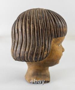 Figure en tête de poupée sculptée d'art populaire antique et effrayante d'un enfant