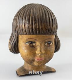 Figure en tête de poupée sculptée d'art populaire antique et effrayante d'un enfant