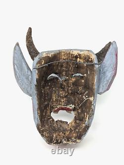 Grande masque de figure diabolique en bois sculpté, d'art populaire ancien, fait et peint à la main