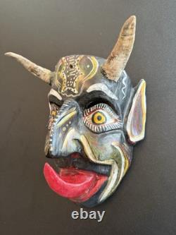 Masque de diable en bois sculpté rouge et noir, art populaire mexicain avec des yeux jaunes et une énorme langue