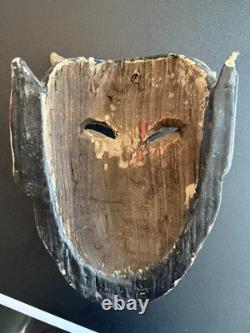 Masque de diable en bois sculpté rouge et noir, art populaire mexicain avec des yeux jaunes et une énorme langue