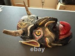 Masque de diable en bois sculpté rouge et noir, art populaire mexicain avec des yeux jaunes et une énorme langue