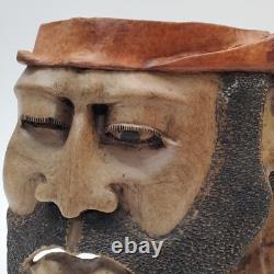 Masque en bois sculpté d'art populaire rustique, homme barbu, yeux creux, décoration des arrière-pays.