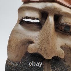 Masque en bois sculpté d'art populaire rustique, homme barbu, yeux creux, décoration des arrière-pays.