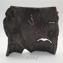 Masque en bois sculpté d'art populaire rustique, homme barbu, yeux creux, décoration des arrière-pays.