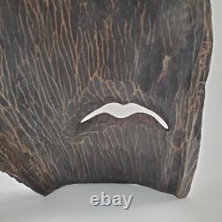 Masque en bois sculpté d'art populaire rustique, homme barbu, yeux creux, décoration des arrière-pays.