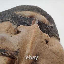 Masque en bois sculpté d'art populaire rustique, homme barbu, yeux creux, décoration des arrière-pays.