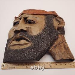 Masque en bois sculpté d'art populaire rustique, homme barbu, yeux creux, décoration des arrière-pays.