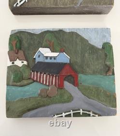 Paire de plaques en bois sculptées à la main en art populaire 3D peintes représentant un barn et un pont couvert de ferme.