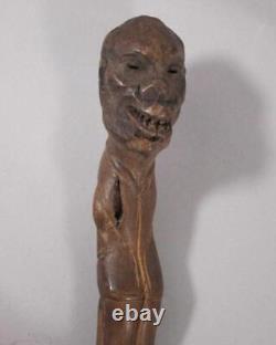Poignée de bâton de marche primitif en bois sculpté d'art populaire avec visage grotesque de crâne