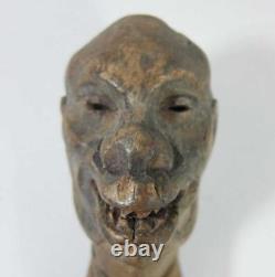 Poignée de bâton de marche primitif en bois sculpté d'art populaire avec visage grotesque de crâne