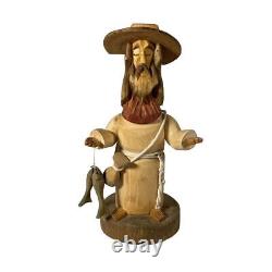 Sculpture en bois d'art populaire signée Pete Ortega : Jésus avec un poisson et un chapeau cassé