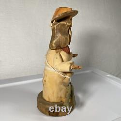 Sculpture en bois d'art populaire signée Pete Ortega : Jésus avec un poisson et un chapeau cassé