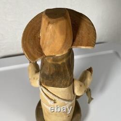 Sculpture en bois d'art populaire signée Pete Ortega : Jésus avec un poisson et un chapeau cassé