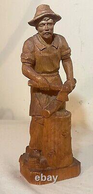 Sculpture statue en bois sculptée à la main d'un bûcheron découpant du bois dans un style folklorique antique