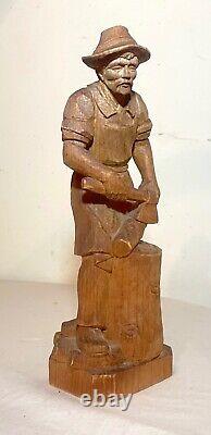 Sculpture statue en bois sculptée à la main d'un bûcheron découpant du bois dans un style folklorique antique