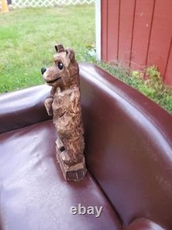 Sculpture sur bois de ourson brun avec une tronçonneuse