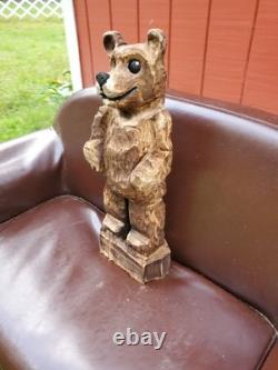 Sculpture sur bois de ourson brun avec une tronçonneuse