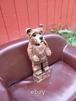 Sculpture sur bois de ourson brun avec une tronçonneuse