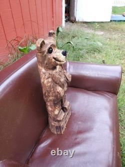 Sculpture sur bois de ourson brun avec une tronçonneuse